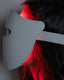 The model wearing Blyss Helio – Professional-Grade LED Photon Therapy Mask